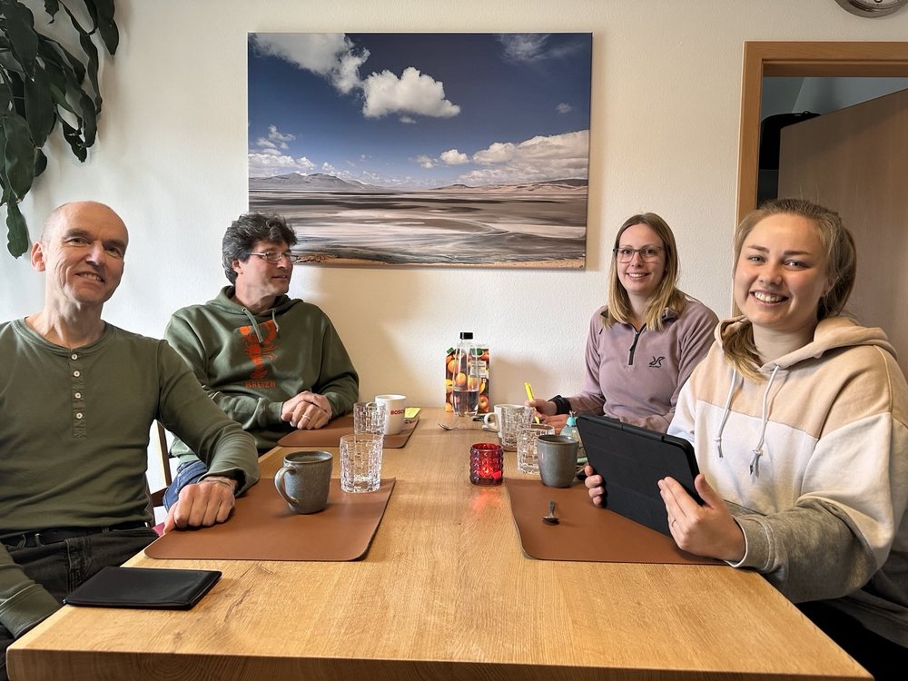 4 Personen an einem Tisch mit Getränken