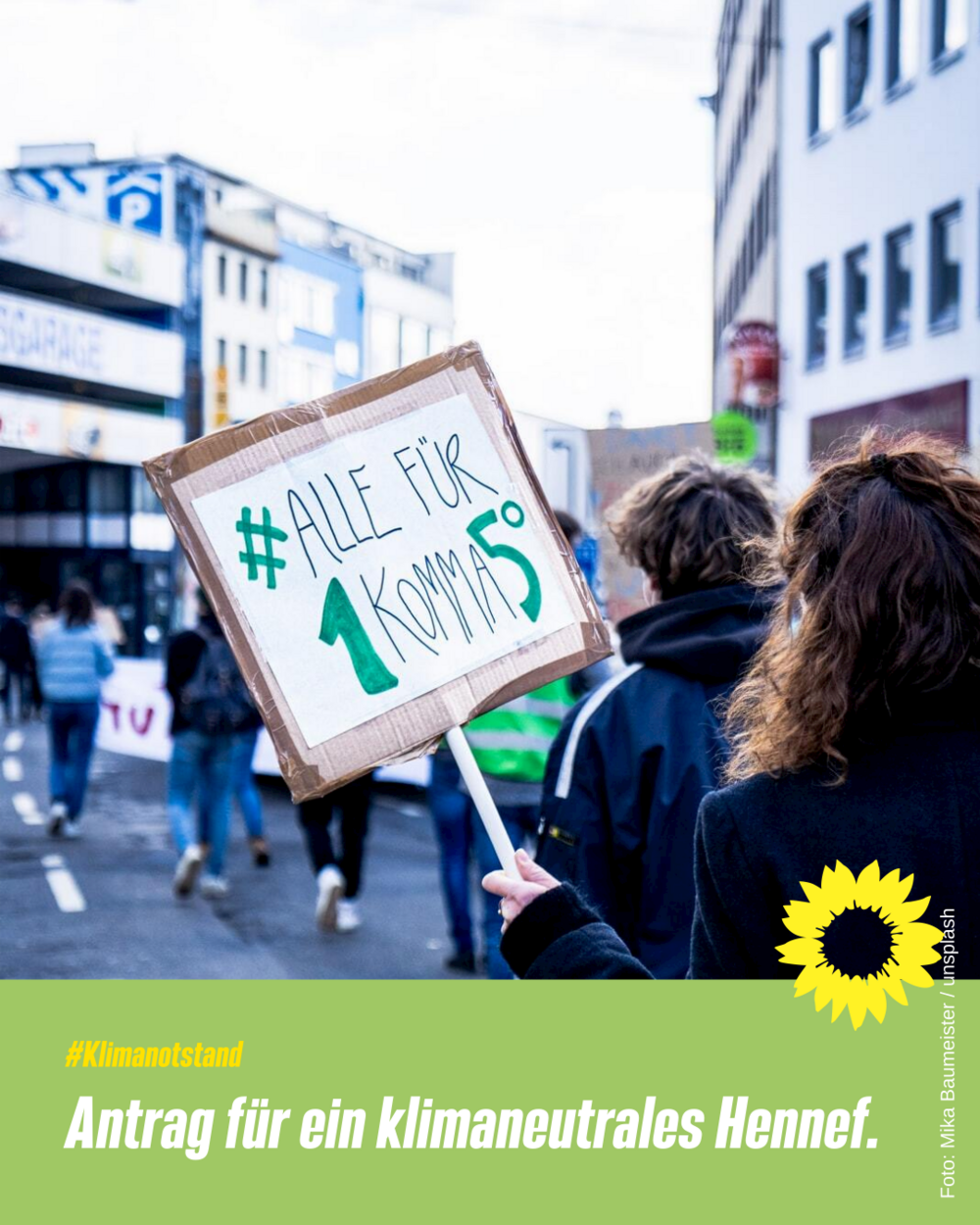 Plakat mit Menschen bei einer Demo und einem Schild "#Alle für 1 Komma 5 Grad" und dem Text unter dem Bild "#Klimanotstand Antrag für ein klimaneutrales Hennef." und einer gelben Sonnenblume