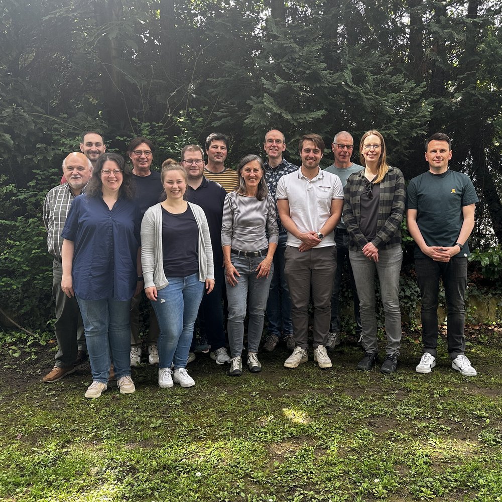 Gruppenfoto der Teilnehmenden des Strategiewochenendes auf Wiese vor Wald