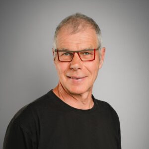 Portraitaufnahme Matthias Ecke vor grauem Hintergrund
