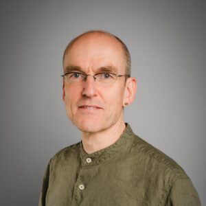 Portraitaufnahme Kay-Henning Gockel vor grauem Hintergrund