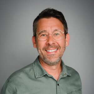 Portraitaufnahme Christian Gunkel vor grauem Hintergrund