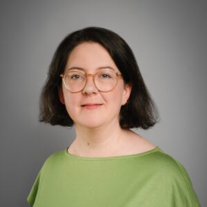 Portraitaufnahme Jennifer Sass vor grauem Hintergrund